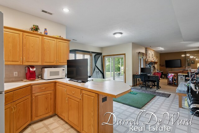2711 Byron Station Dr SW, Byron Center, MI 49315 - kitchen with light flooring, light countertops, a peninsula, white microwave, and open floor plan