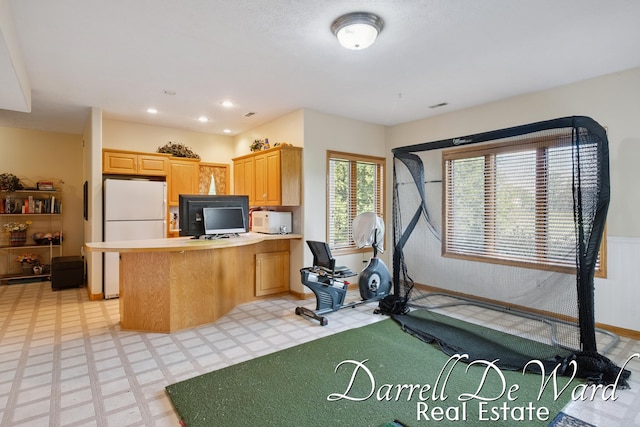 2711 Byron Station Dr SW, Byron Center, MI 49315 - kitchen featuring freestanding refrigerator, a peninsula, light flooring, built in desk, and light countertops