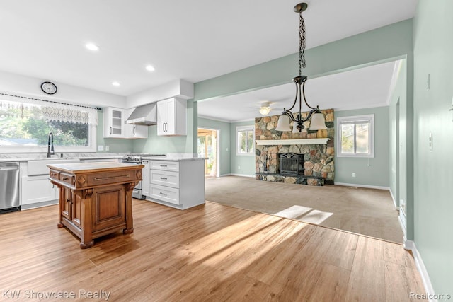 1830 Majon, Highland, MI 48356 - kitchen featuring light wood finished floors, butcher block counters, white cabinets, a stone fireplace, and recessed lighting