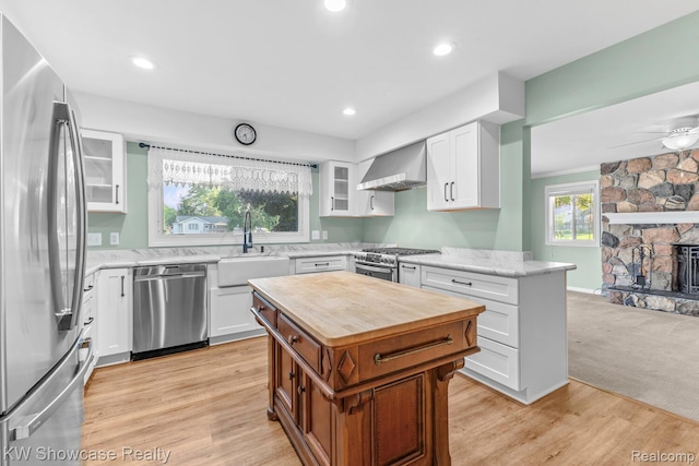 1830 Majon, Highland, MI 48356 - kitchen featuring appliances with stainless steel finishes, wooden counters, glass insert cabinets, wall chimney range hood, and white cabinets