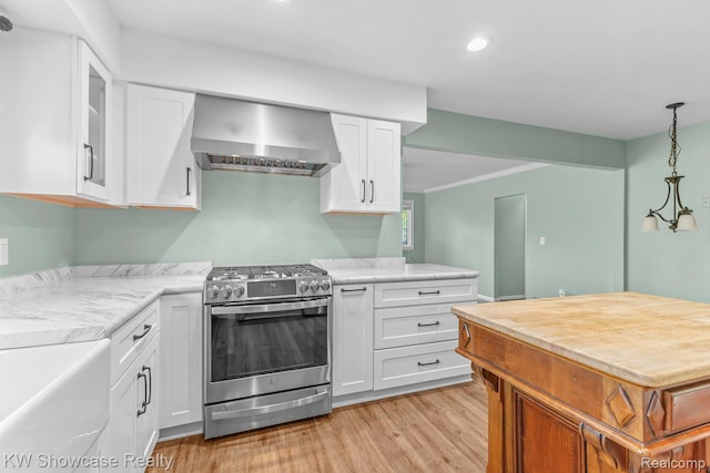 1830 Majon, Highland, MI 48356 - kitchen with wall chimney range hood, gas stove, white cabinetry, light wood-type flooring, and recessed lighting