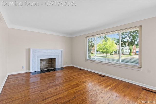7235 Stout St, Detroit, MI 48228 - unfurnished living room with wood finished floors and a fireplace with flush hearth