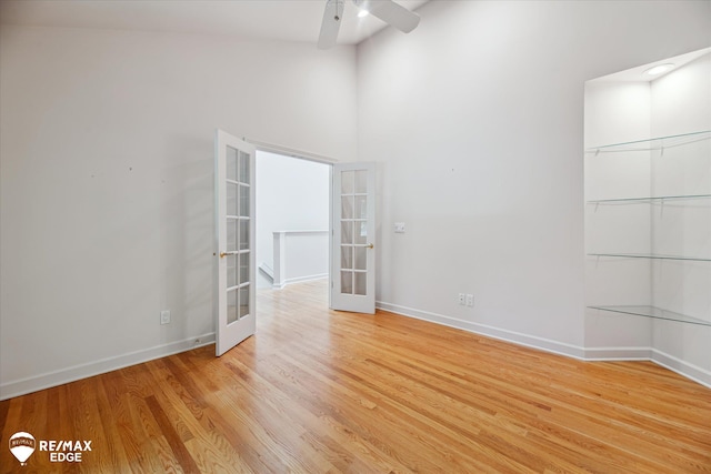 8078 Hawkcrest Dr, Grand Blanc, MI 48439 - empty room featuring french doors, a ceiling fan, light wood-type flooring, and a high ceiling