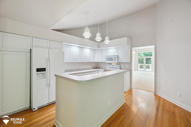 8078 Hawkcrest Dr, Grand Blanc, MI 48439 - kitchen with white appliances, light countertops, light wood-style floors, backsplash, and high vaulted ceiling