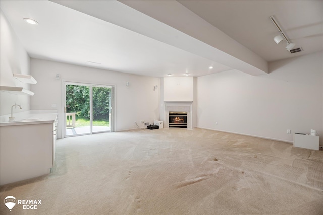 8078 Hawkcrest Dr, Grand Blanc, MI 48439 - unfurnished living room with light carpet, a warm lit fireplace, track lighting, and recessed lighting