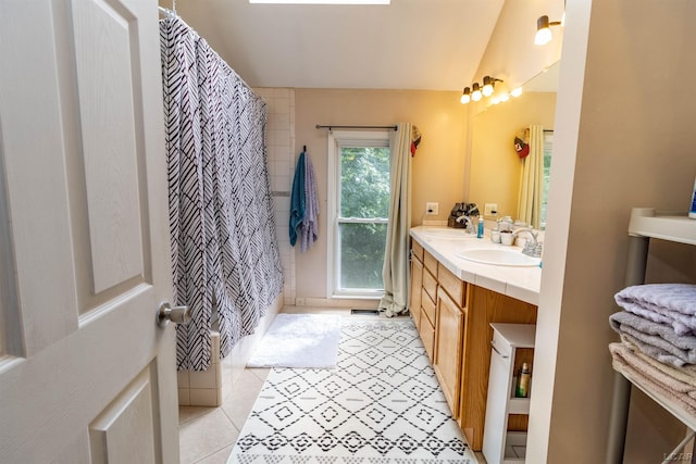 1193 Seneca St, Adrian, MI 49221 - bathroom with double vanity, vaulted ceiling, a shower with shower curtain, and tile patterned flooring