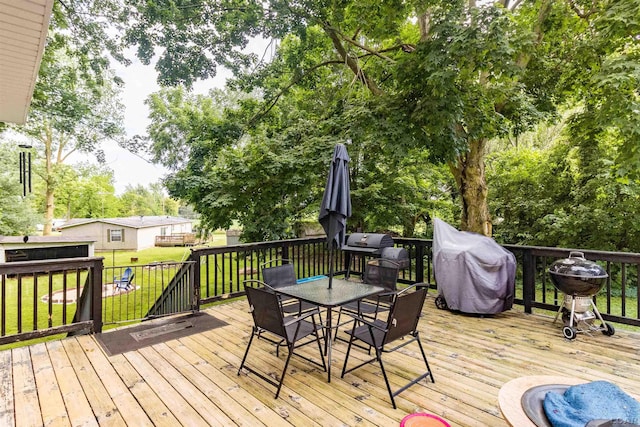1193 Seneca St, Adrian, MI 49221 - wooden deck with outdoor dining area, a yard, and area for grilling
