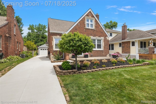 1816 Roslyn Rd, Grosse Pointe Woods, MI 48236 - tudor house with brick siding, an outbuilding, a front lawn, and roof with shingles