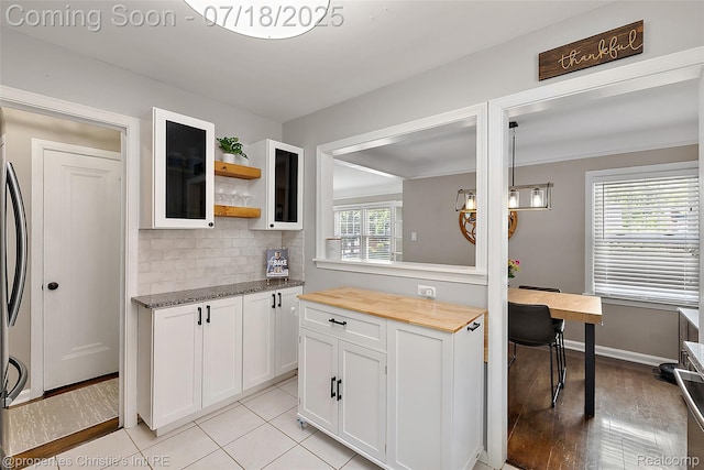 1816 Roslyn Rd, Grosse Pointe Woods, MI 48236 - kitchen featuring white cabinetry, tasteful backsplash, wood counters, glass insert cabinets, and open shelves