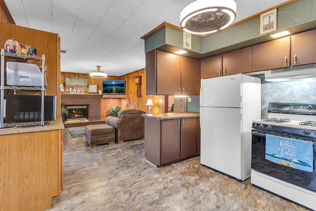 11585 Onsted Hwy, Brooklyn, MI 49230 - kitchen featuring range with gas stovetop, freestanding refrigerator, wood walls, under cabinet range hood, and open floor plan