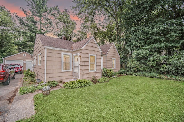 5097 Jackson Rd, Ann Arbor, MI 48103 - view of front facade with a chimney, a front lawn, an outdoor structure, a shingled roof, and a garage