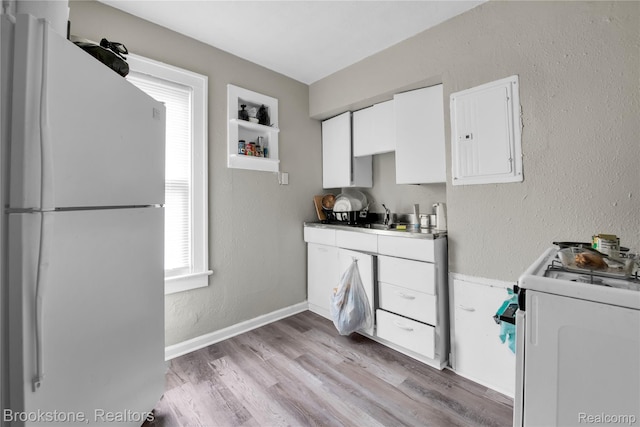 13528 Ardmore St, Detroit, MI 48227 - kitchen with white appliances, white cabinetry, plenty of natural light, light wood-style floors, and a textured wall