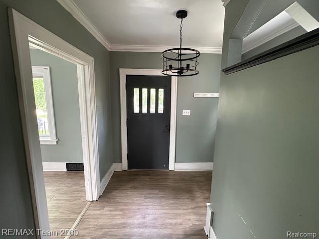 214 E Hazelhurst St, Ferndale, MI 48220 - foyer entrance featuring ornamental molding, a chandelier, and wood finished floors