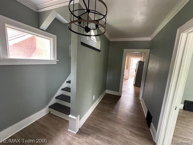 214 E Hazelhurst St, Ferndale, MI 48220 - hallway with stairs, wood finished floors, a chandelier, and crown molding