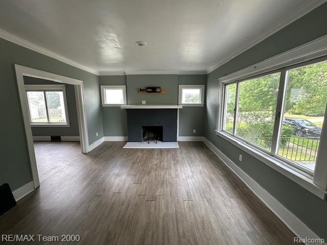 214 E Hazelhurst St, Ferndale, MI 48220 - unfurnished living room with plenty of natural light, a fireplace, dark wood-style flooring, and crown molding