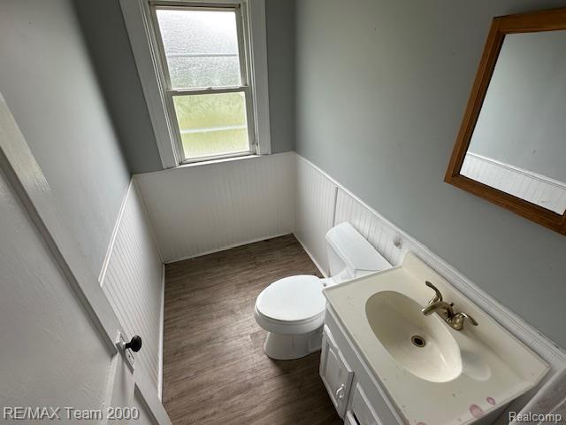 214 E Hazelhurst St, Ferndale, MI 48220 - half bathroom featuring a wainscoted wall, vanity, and wood finished floors