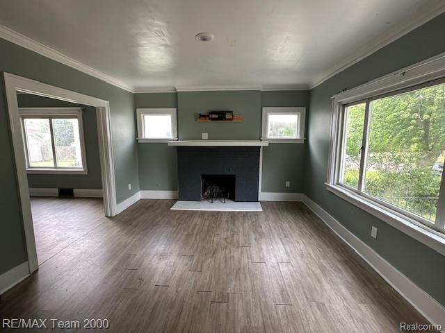 214 E Hazelhurst St, Ferndale, MI 48220 - unfurnished living room with a fireplace, plenty of natural light, dark wood-style floors, and crown molding