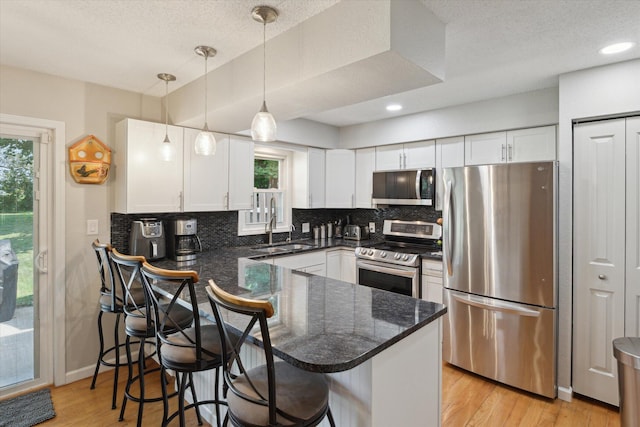10999 M 140, Niles, MI 49120 - kitchen featuring stainless steel appliances, a peninsula, white cabinets, decorative backsplash, and a textured ceiling