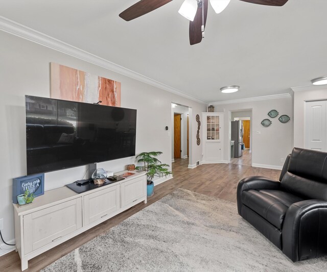 700 Devonshire Rd, Fowlerville, MI 48836 - living room with ornamental molding, a ceiling fan, and light wood-style floors
