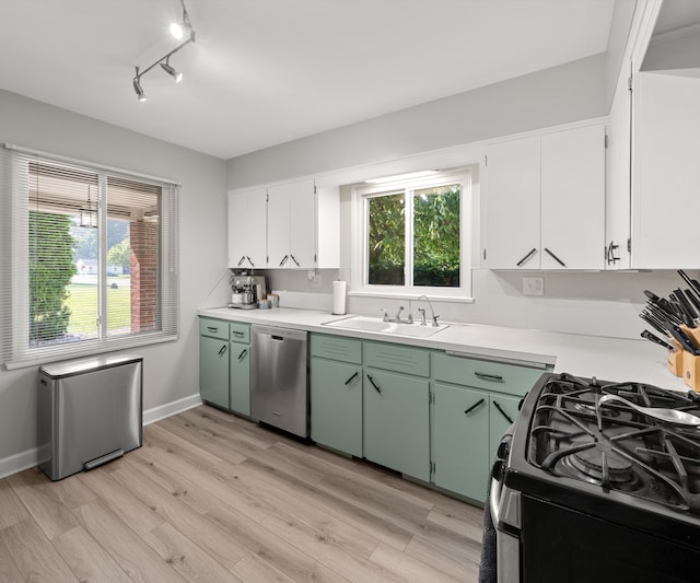 700 Devonshire Rd, Fowlerville, MI 48836 - kitchen featuring appliances with stainless steel finishes, light countertops, light wood finished floors, white cabinetry, and track lighting