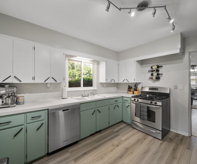 700 Devonshire Rd, Fowlerville, MI 48836 - kitchen with appliances with stainless steel finishes, light countertops, light wood-style floors, white cabinetry, and green cabinetry