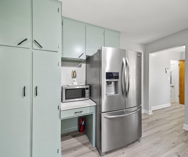 700 Devonshire Rd, Fowlerville, MI 48836 - kitchen featuring appliances with stainless steel finishes, light wood-style flooring, light countertops, and green cabinetry