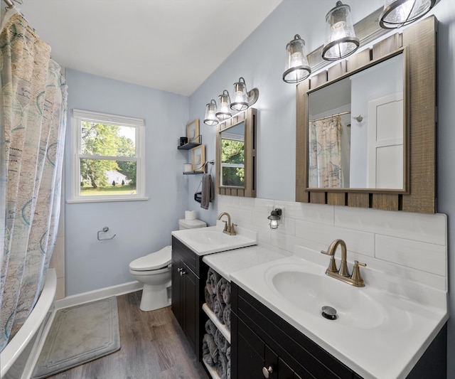 700 Devonshire Rd, Fowlerville, MI 48836 - full bath featuring wood finished floors, vanity, shower / bath combo with shower curtain, and backsplash