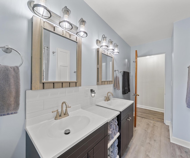 700 Devonshire Rd, Fowlerville, MI 48836 - bathroom with two vanities, wood finished floors, and decorative backsplash