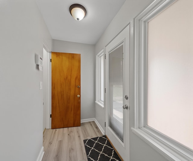 700 Devonshire Rd, Fowlerville, MI 48836 - doorway to outside featuring light wood-style floors and baseboards