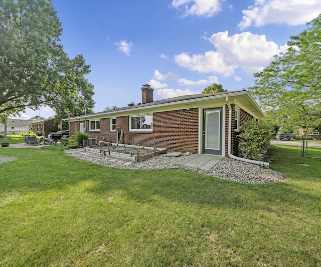 700 Devonshire Rd, Fowlerville, MI 48836 - back of house with brick siding, a chimney, and a patio area