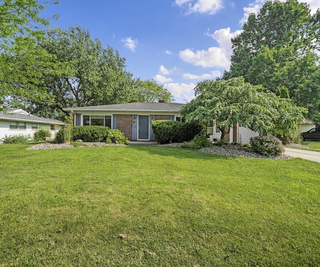 700 Devonshire Rd, Fowlerville, MI 48836 - view of front of property with a front lawn, brick siding, a chimney, and a garage