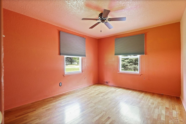 2113 Bock Rd, Saginaw, MI 48603 - unfurnished room with wood finished floors, a textured ceiling, a textured wall, and a ceiling fan