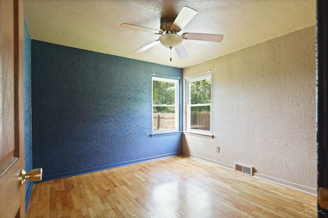 2113 Bock Rd, Saginaw, MI 48603 - unfurnished room featuring a textured wall, wood finished floors, ceiling fan, and a textured ceiling