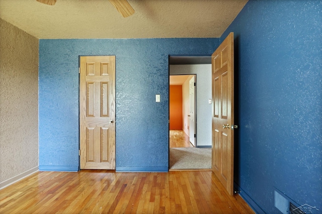 2113 Bock Rd, Saginaw, MI 48603 - unfurnished bedroom with wood finished floors, a textured wall, a textured ceiling, and a ceiling fan