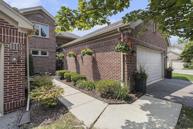 113 Ponds View Dr, Ann Arbor, MI 48103 - view of property exterior with brick siding, driveway, an attached garage, and a shingled roof