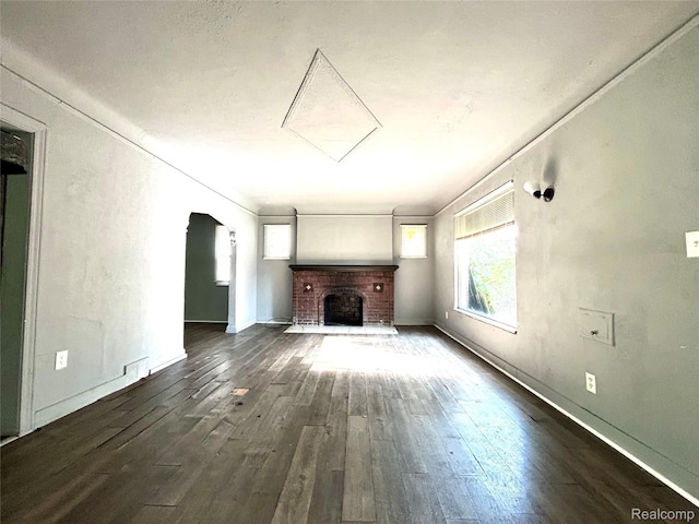 14869 Mark Twain St, Detroit, MI 48227 - unfurnished living room with dark wood-style floors, arched walkways, and a brick fireplace