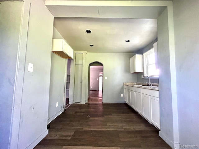 14869 Mark Twain St, Detroit, MI 48227 - kitchen with arched walkways, dark wood finished floors, white cabinetry, and light countertops