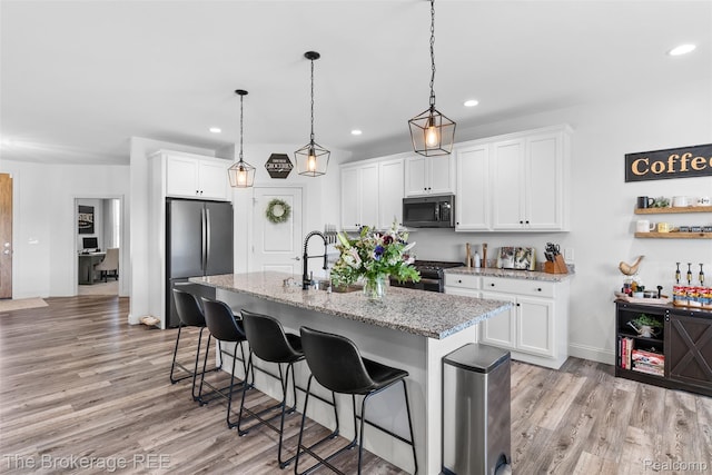 6264 Hidden Forrest, Swartz Creek, MI 48473 - kitchen featuring recessed lighting, freestanding refrigerator, light wood finished floors, a kitchen bar, and white cabinets