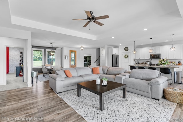 6264 Hidden Forrest, Swartz Creek, MI 48473 - living area featuring light wood finished floors, recessed lighting, a tray ceiling, and a ceiling fan