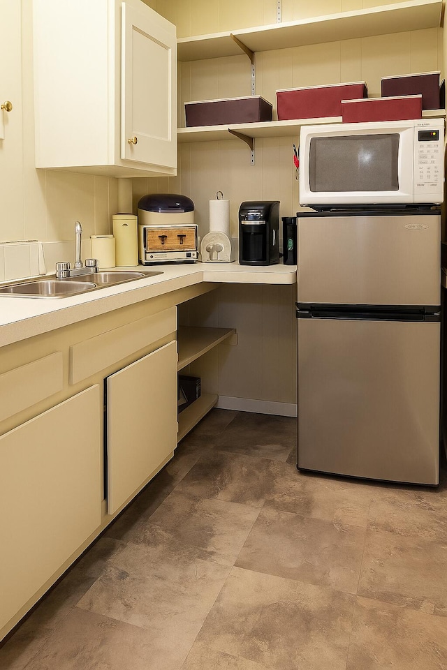 28740 Tavistock Trl, Southfield, MI 48034 - kitchen featuring freestanding refrigerator, white microwave, open shelves, white cabinetry, and light countertops
