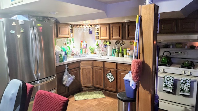 28740 Tavistock Trl, Southfield, MI 48034 - kitchen featuring freestanding refrigerator, white gas stove, brown cabinets, tile counters, and light flooring