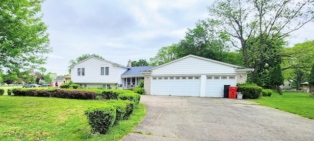 28740 Tavistock Trl, Southfield, MI 48034 - tri-level home with asphalt driveway, a front lawn, and a garage