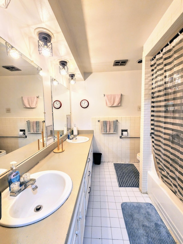 28740 Tavistock Trl, Southfield, MI 48034 - bathroom with tile patterned flooring, tile walls, double vanity, shower / bath combo, and a wainscoted wall