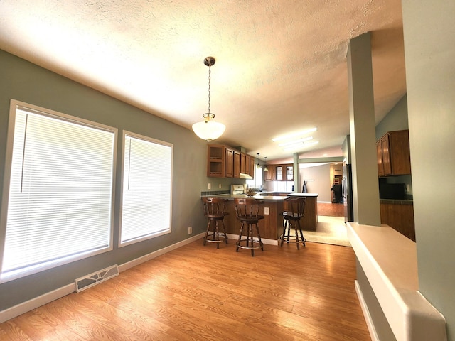 6580 Deerfield Trl, Lake, MI 48632 - dining room with light wood-style flooring, lofted ceiling, and a textured ceiling