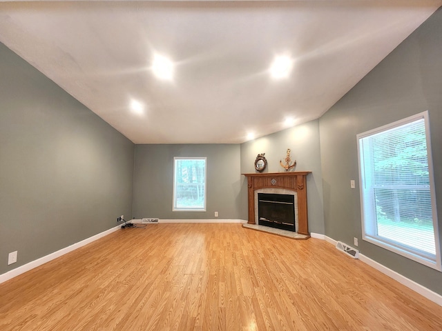 6580 Deerfield Trl, Lake, MI 48632 - unfurnished living room with light wood-style flooring and a tiled fireplace