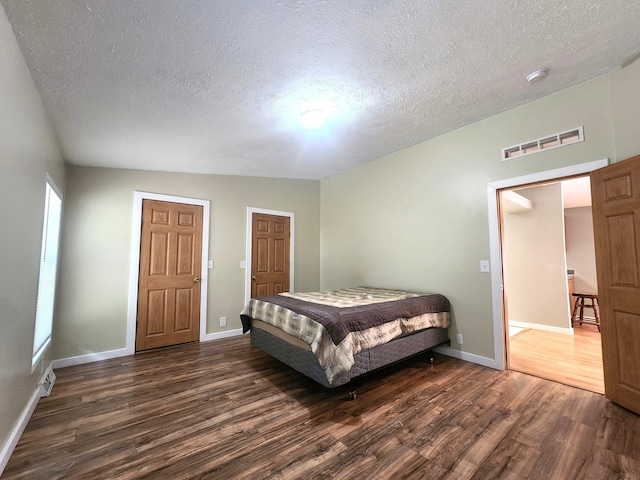 6580 Deerfield Trl, Lake, MI 48632 - bedroom featuring dark wood finished floors and a textured ceiling