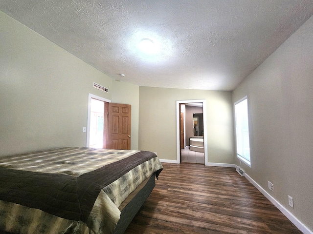 6580 Deerfield Trl, Lake, MI 48632 - bedroom featuring dark wood-style flooring, a textured ceiling, and ensuite bath