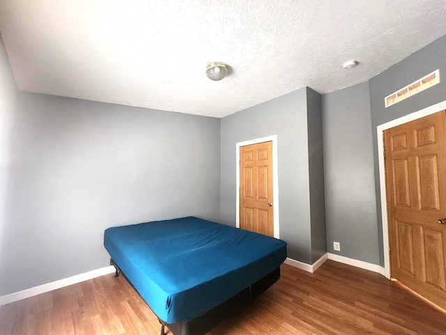 6580 Deerfield Trl, Lake, MI 48632 - bedroom featuring wood finished floors and a textured ceiling