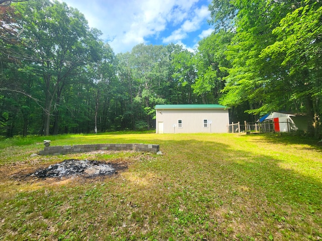 6580 Deerfield Trl, Lake, MI 48632 - view of green lawn with a pole building, an outbuilding, and a wooded view
