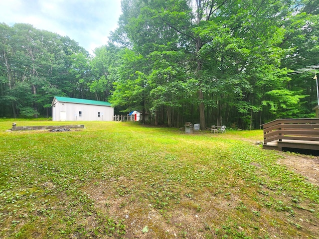 6580 Deerfield Trl, Lake, MI 48632 - view of green lawn with an outbuilding, a wooden deck, and a forest view